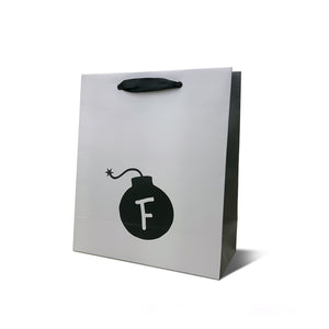 F Bomb white gift bag with black ribbon handle and black cannonball with F design
